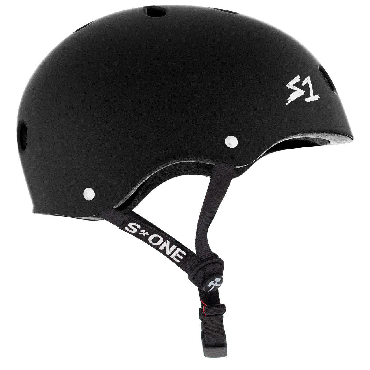 A **S-One Helmet Mega Lifer Black Matte** branded skate helmet features multiple ventilation holes, an adjustable chin strap, and high-impact protection.