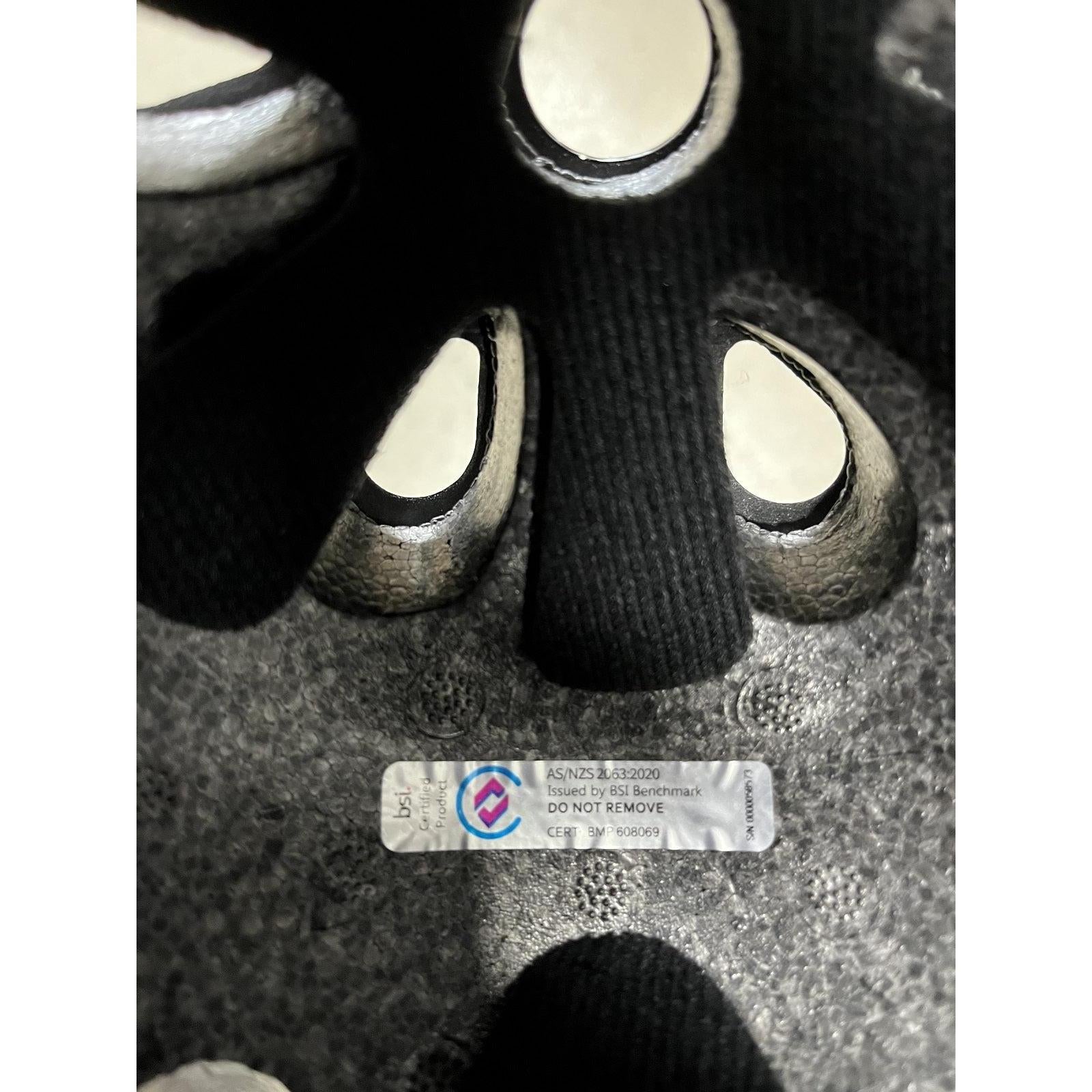 Interior of the S-One Lifer Helmet / Black Matte/Cyan Straps showing a compliance sticker with AS/NZS 4330:2020 certification issued by BSI Benchmark.