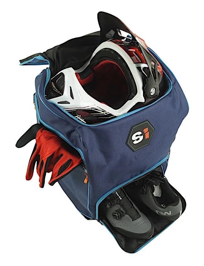 A blue S1 Helmet / Gear Backpack with an open top, holding a helmet, red gloves, and a separate lower compartment for black cycling shoes.