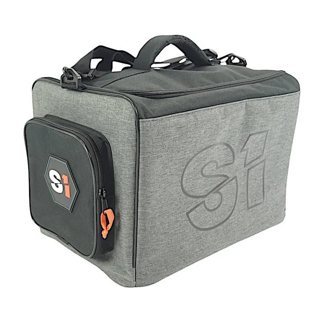 The S1 Helmet / Gear Bag V2 is a gray soft-sided bag with a black side pocket, orange zipper pull, and bold "Si" logos—ideal for carrying your race kit or helmet.