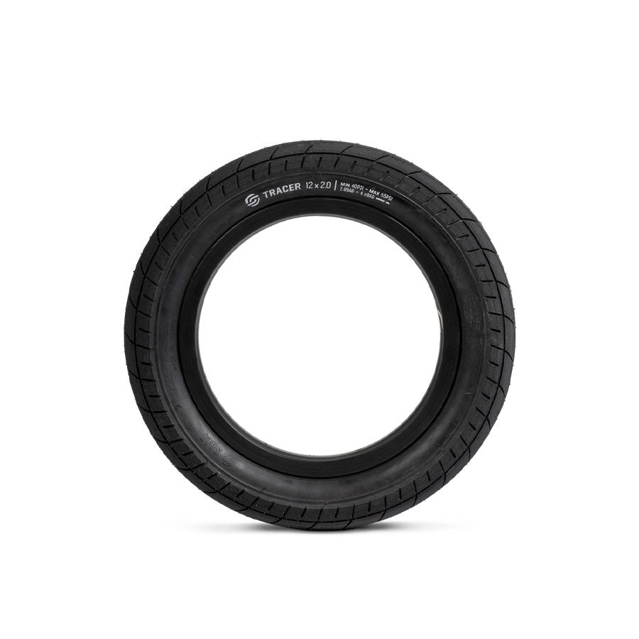A black rubber tire with a visible tread pattern, labeled "Salt Tracer 12 Inch Tyre" on the sidewall, is shown against a plain white background. This versatile tyre offers improved traction, making it an ideal affordable BMX tyre for riders of all skill levels.
