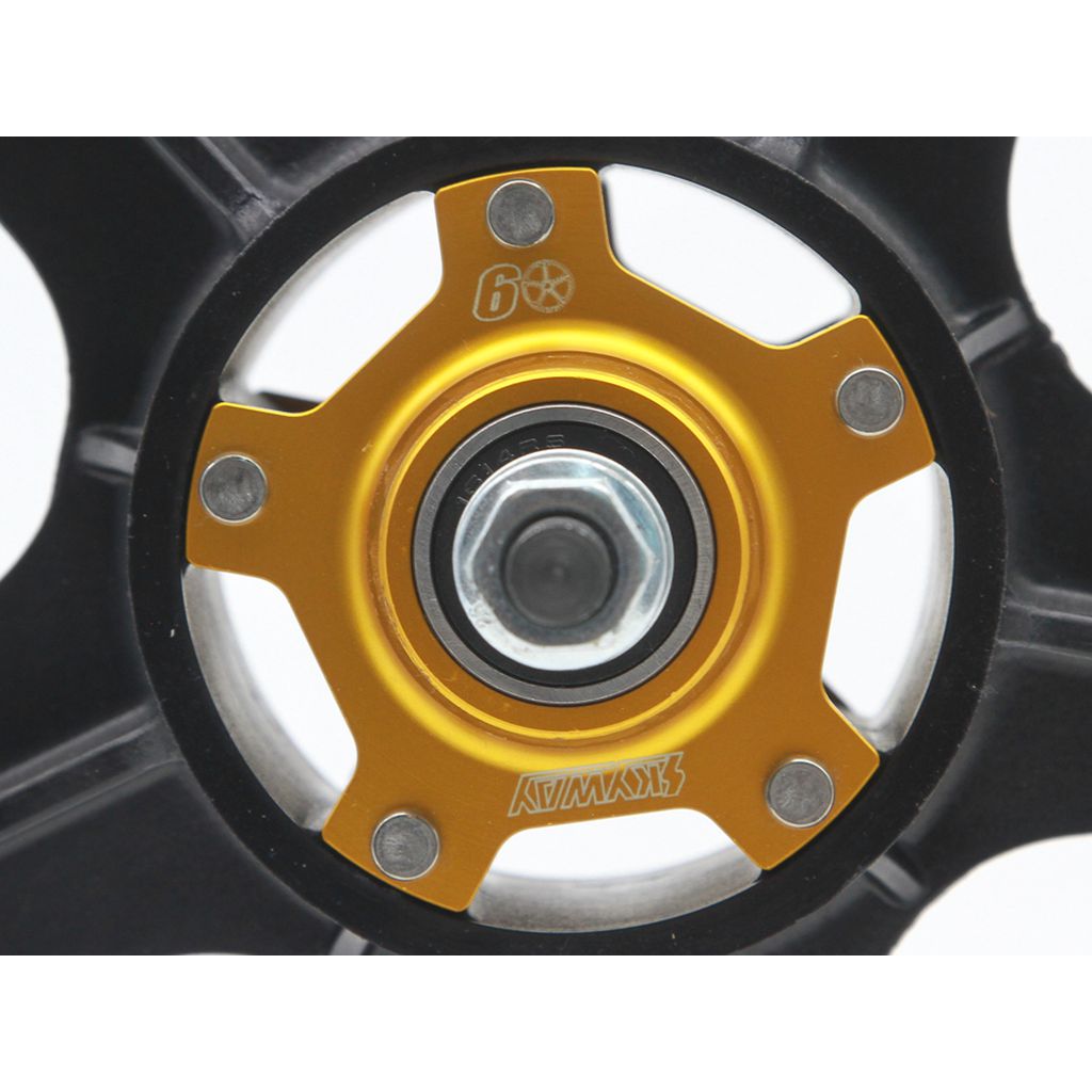 Close-up of a Skyway TUFF II 60th Anniversary Graphite Edition 20 Inch wheel hub, showing gold and black details, bolts, bearing, and engraved branding with numbers on the metal surface.