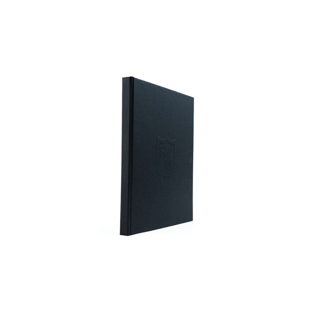 A black S&M Behind The Shield Book on a white background.