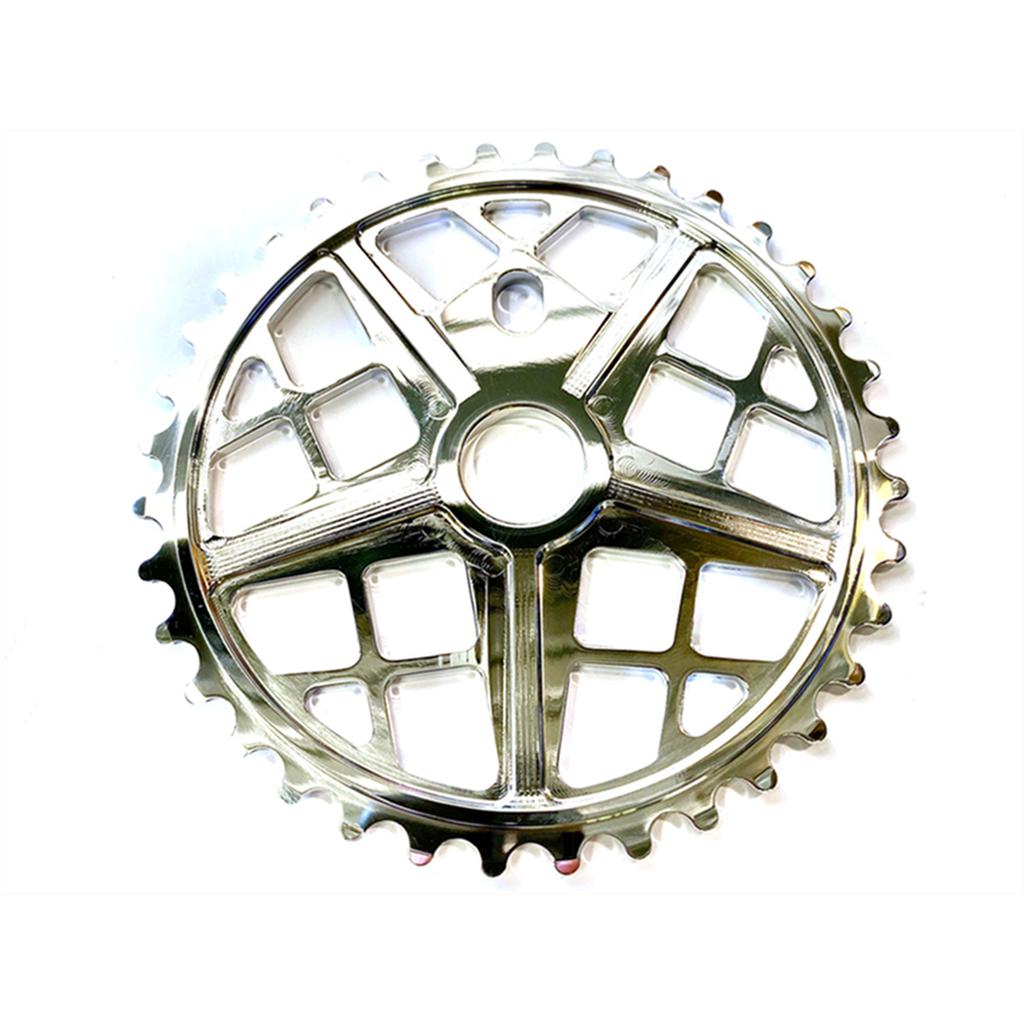 The S&M Motoman Sprocket is crafted from CNC machined 6061 T6 Aluminum, featuring a silver finish with a circular, gear-like design and lattice-style cutouts.