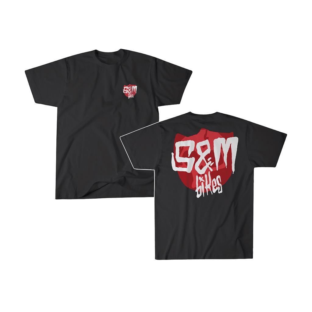 The S&M Skull Shield T-Shirt is made from 100% combed cotton and displays the "S&M Bikes" logo in red and white. Printed in the USA, it features a small logo on the left chest and a large one on the back.