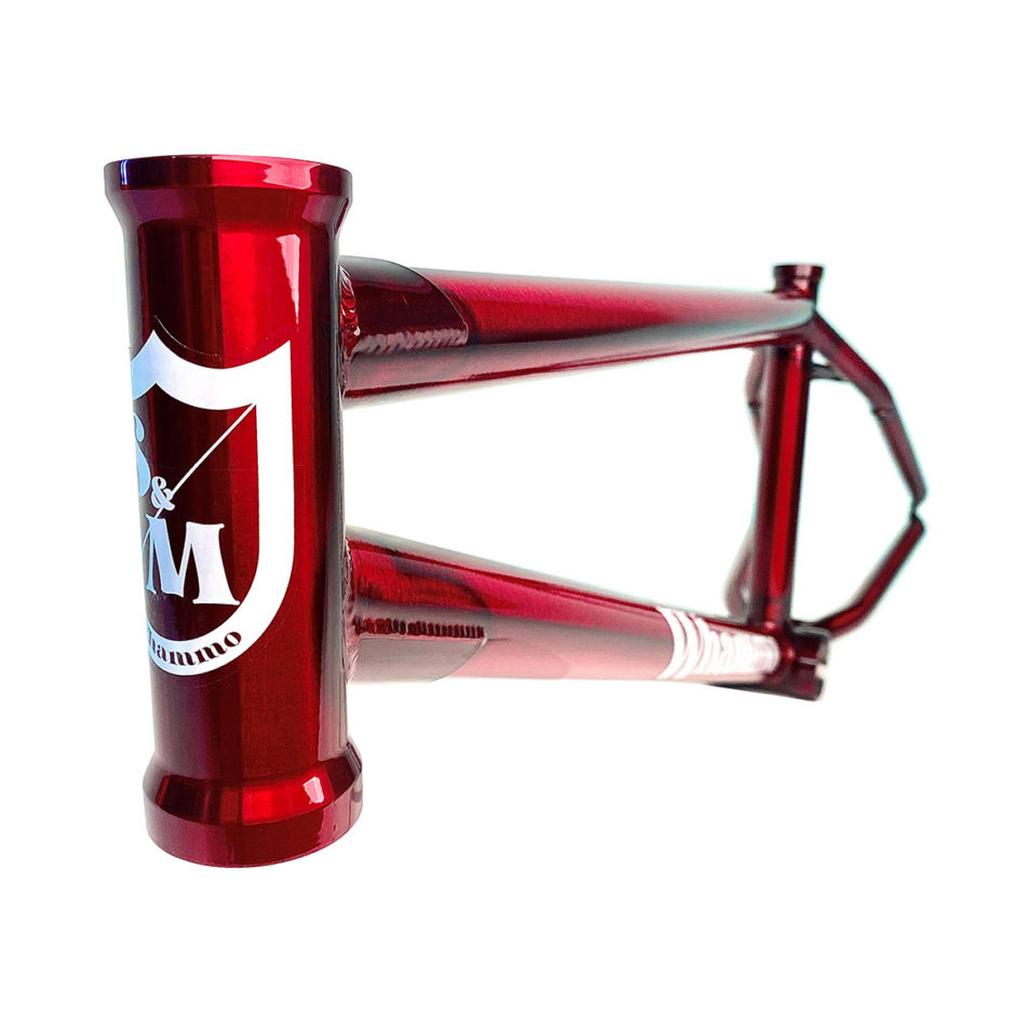 The S&M Whammo V2 (Craig Passero) Frame features a close-up of its red metallic finish and simple design, with a street-focused frame including a higher bottom bracket. Its head tube showcases a shield logo and text.