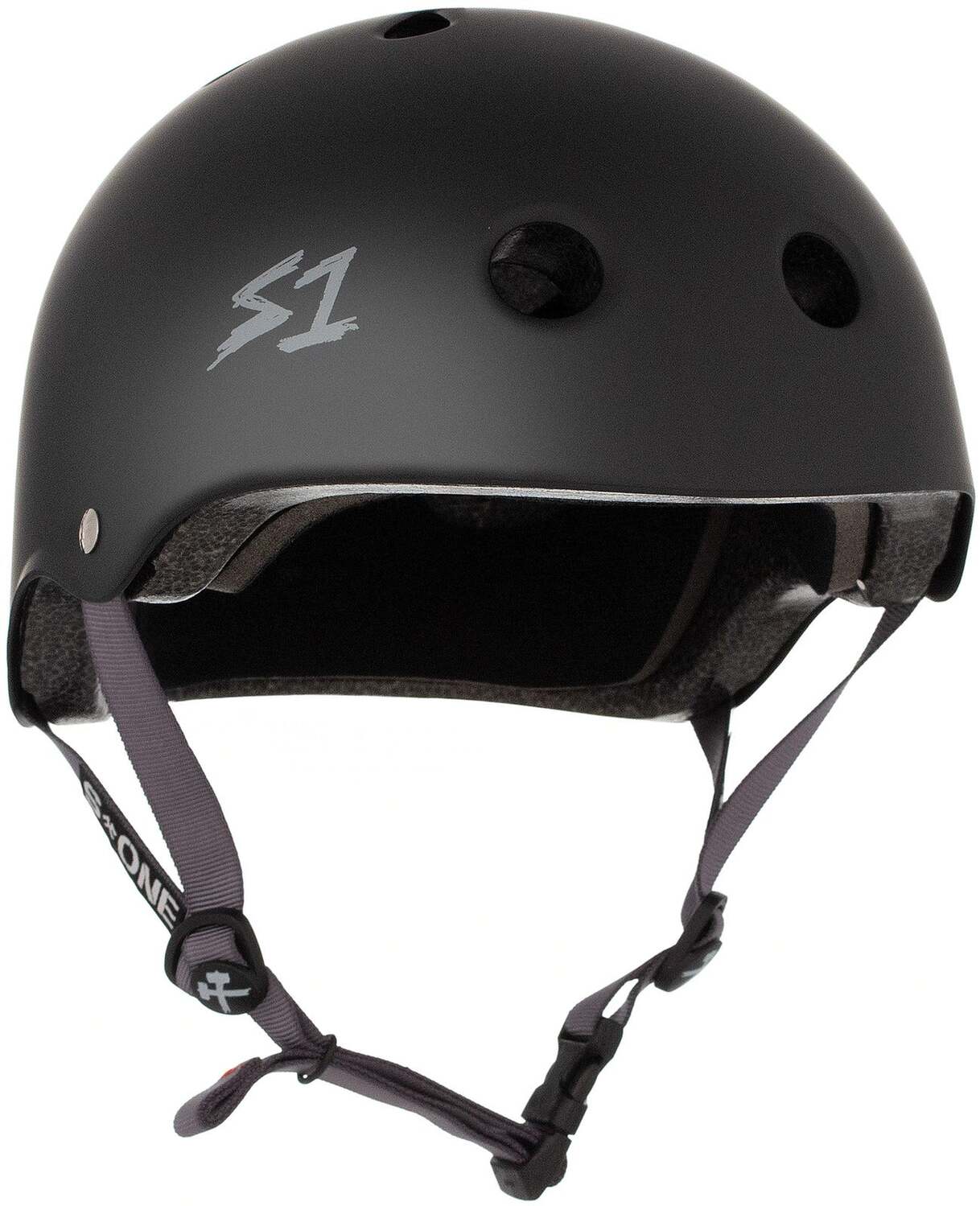 The S-One Lifer Helmet in black matte with grey straps features ventilation holes, an adjustable chin strap, a certified skate helmet design, and side "S1" logo for multiple impact protection.