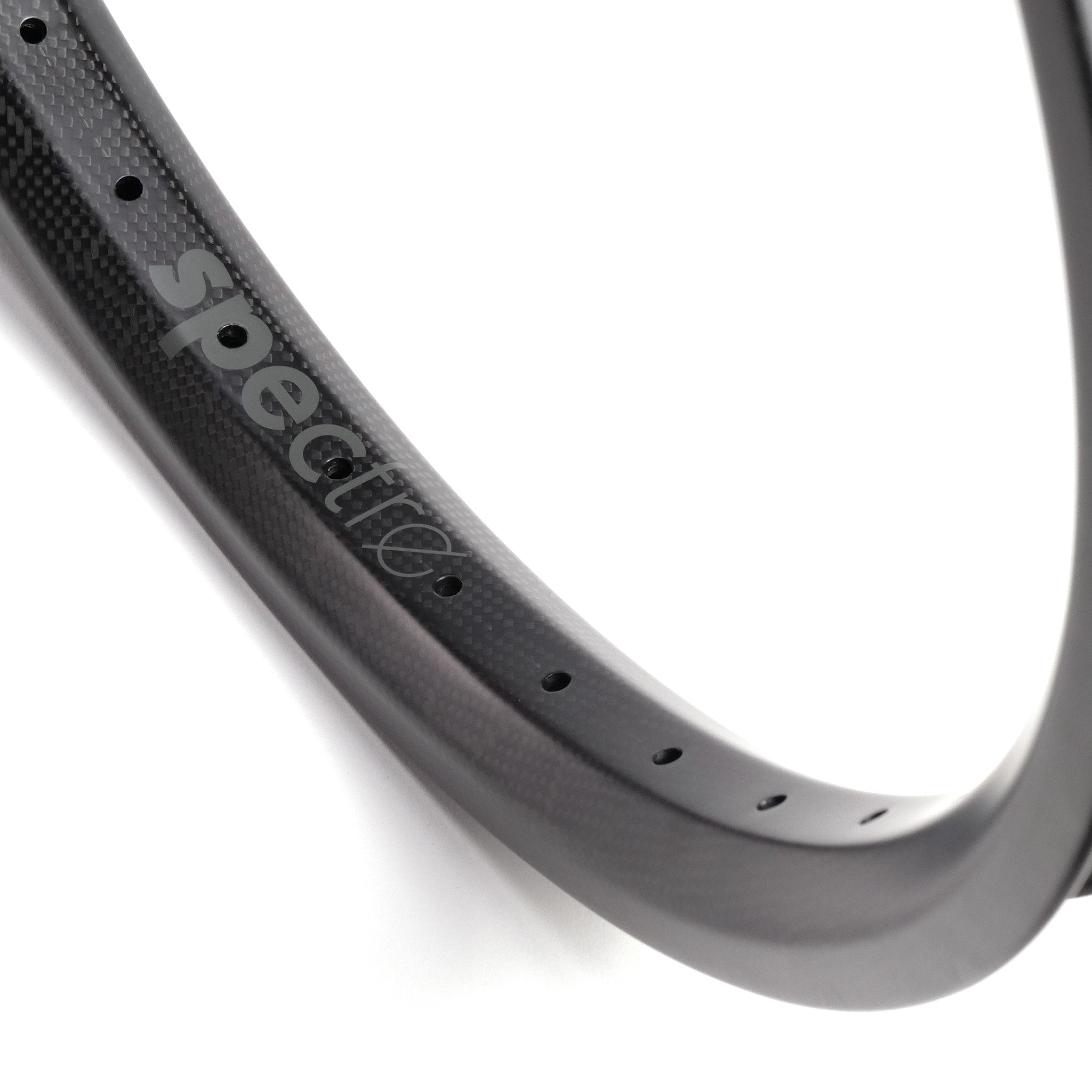 Close-up of a black Spectre NME Carbon Fiber 20 Inch Brakeless Rim, featuring the word "spectro" printed on it. The lightweight rim is crafted from carbon fiber and has multiple spoke holes.