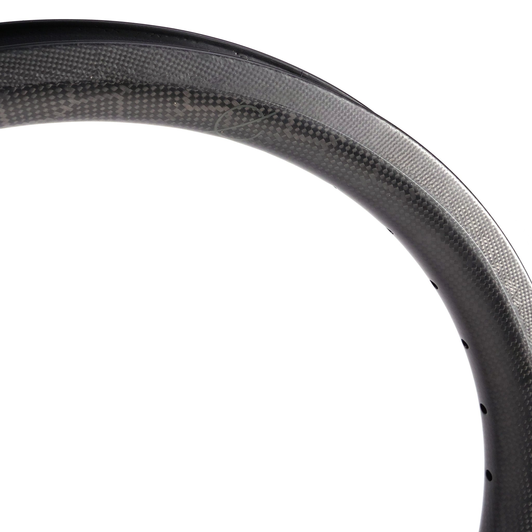 Close-up of a Spectre V2 Carbon Fiber 20 Inch 36H Brake Rim, showcasing its smooth, dark surface and visible circular pattern, emphasizing the lightweight craftsmanship from advanced carbon fiber.