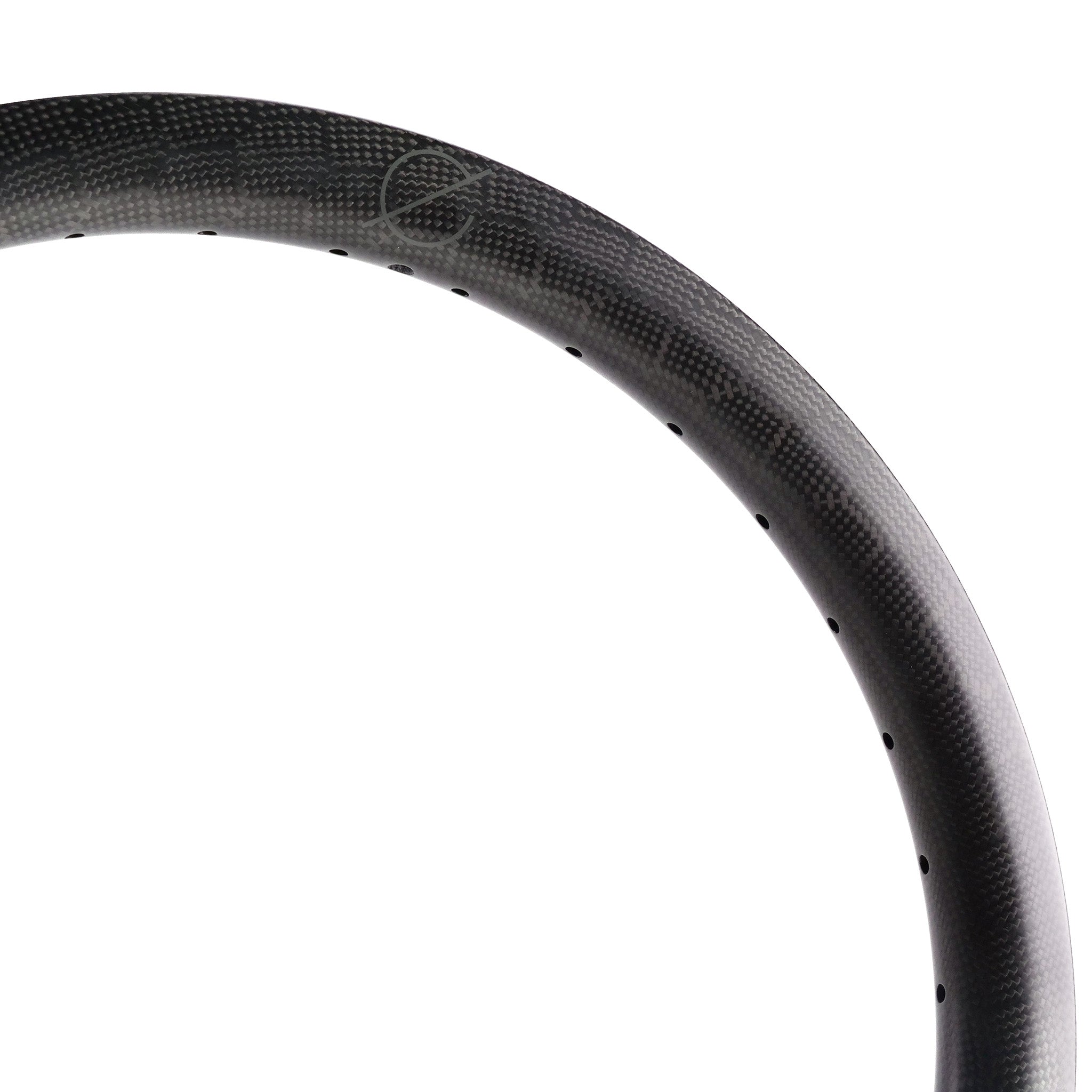 Close-up of the Spectre V2 Carbon Fiber 20 Inch 36H Brakeless Rim, highlighting its strength and lightweight design with spoke holes, showcasing its texture and curvature against a white background.