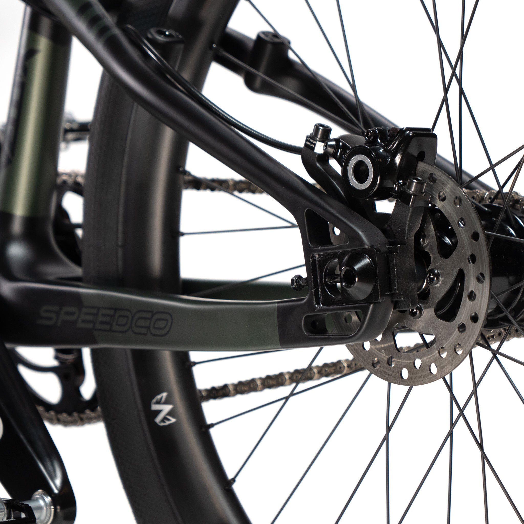 Close-up of the rear disc brake and wheel of a Speedco Velox Pro XL Cruiser Custom Bike, featuring the brand name "Speedco" on the frame.