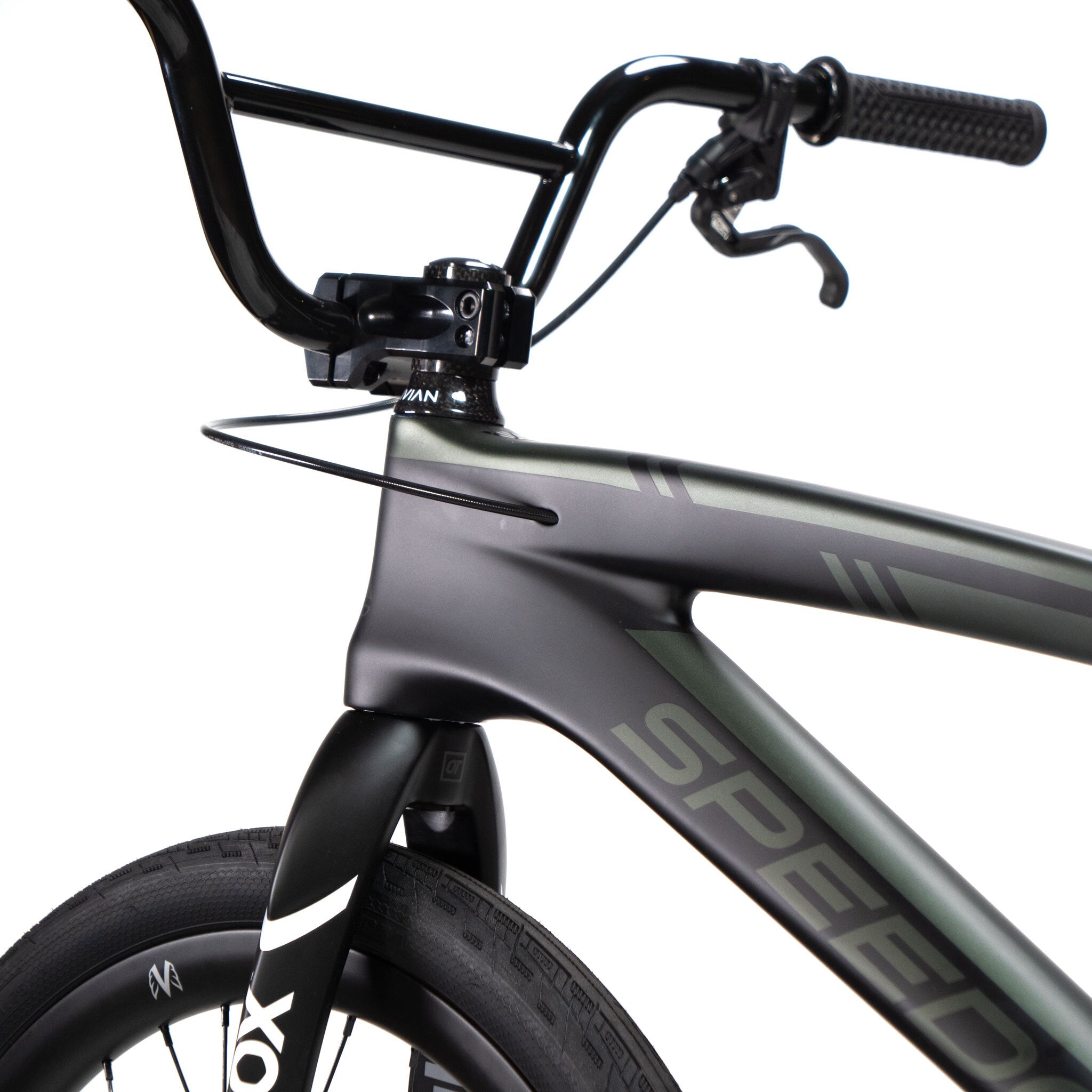 Close-up of a bicycle's front end highlighting the handlebars, brake lever, and part of the front wheel. The black and gray frame is labeled "Speedco Velox Pro XL Cruiser Custom Bike," showcasing a sleek design built for speed.