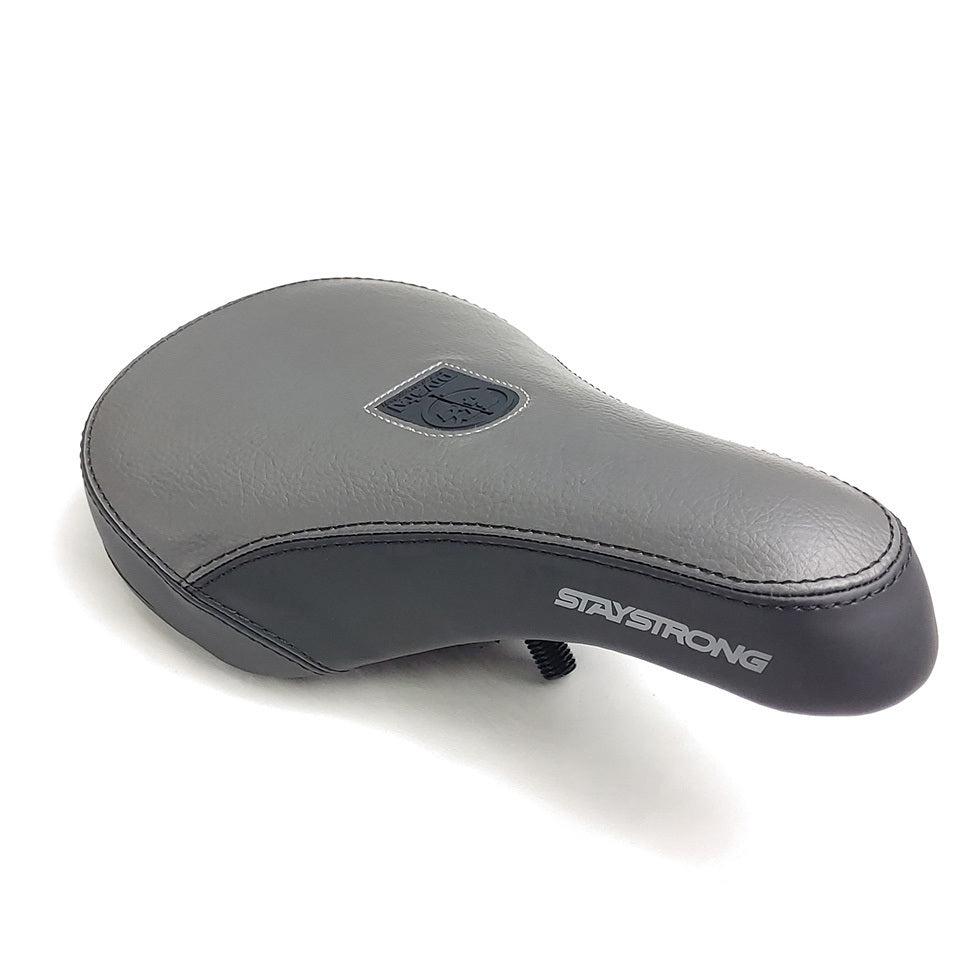 The Stay Strong Combo Mid Pivotal Seat features a gray design with black trim, visible stitching, a central patch, "STAYSTRONG" side branding, and a pivotal seat design for enhanced comfort and style.