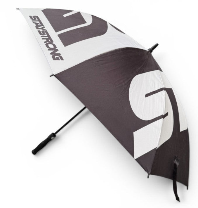The Staystrong Umbrella is a black and white, golf-sized umbrella featuring large stylized letters and the word “BRIDGESTONE” printed along one edge. Designed for rainy race days, it has a black handle and is shown partially open.