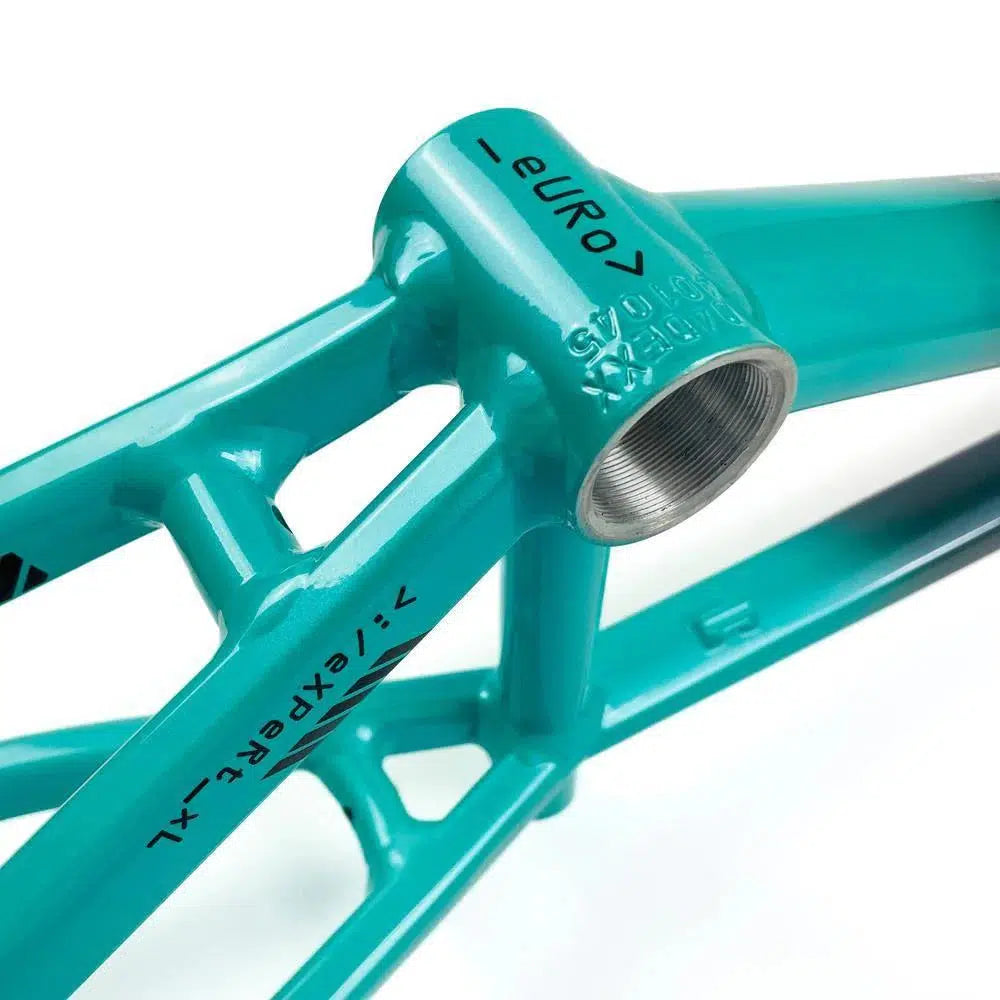 Close-up of a teal bicycle frame crafted from 6061 alloy tubing, showcasing detailed welding work and printed text that reads "Staystrong V5 Disc Expert XL Frame" and "euro 7." The aluminium race frame design embodies durability, making every ride exceptional.