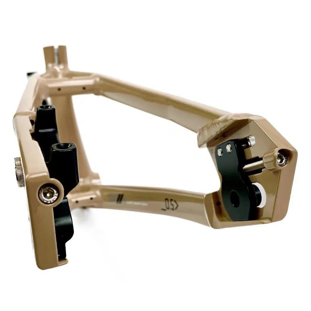A close-up view of a beige metal object with black components, featuring an aluminium race frame for Staystrong V5 Disc Pro Cruiser Frame and various bolts and screws.
