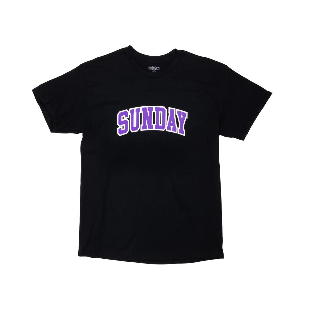 The Sunday Blockhead T-Shirt features "SUNDAY" in bold, purple arched block letters across the chest—a stylish black tee perfect for everyday wear.