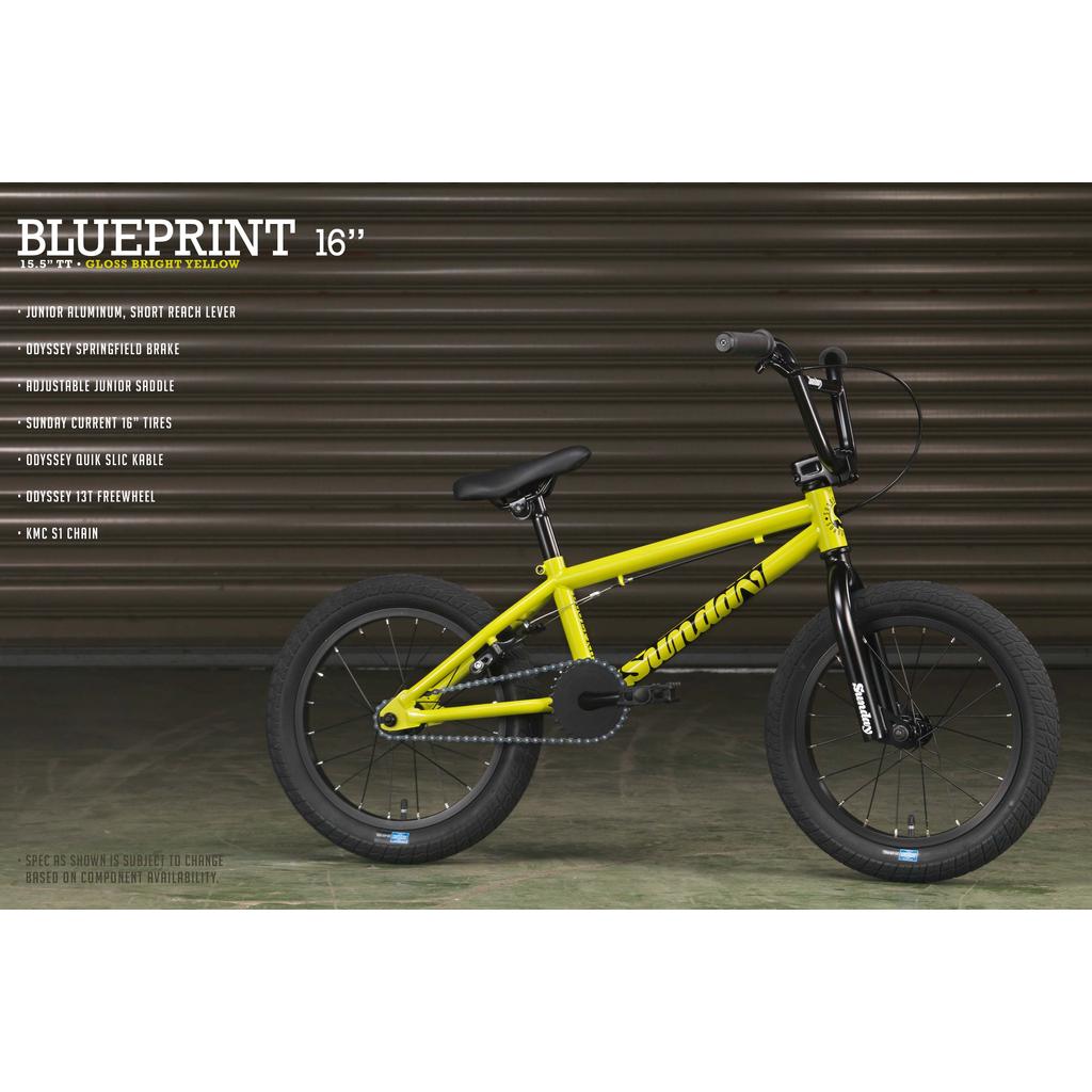 The Sunday Blueprint 16 Inch Bike in gloss yellow with black tires and components is shown indoors before a metal shutter. Text highlights include its scaled-down geometry and Odyssey Springfield Brakes.