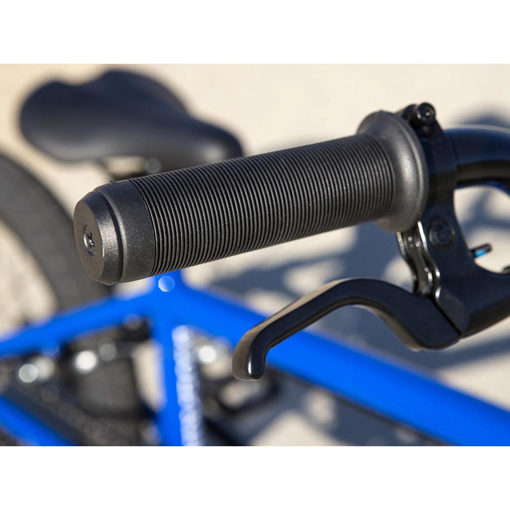 Close-up of a black handlebar grip and brake lever, featuring Odyssey Springfield Brakes on a blue Sunday Blueprint 16 Inch Bike with BMX geometry; the bicycle seat is seen in the background.