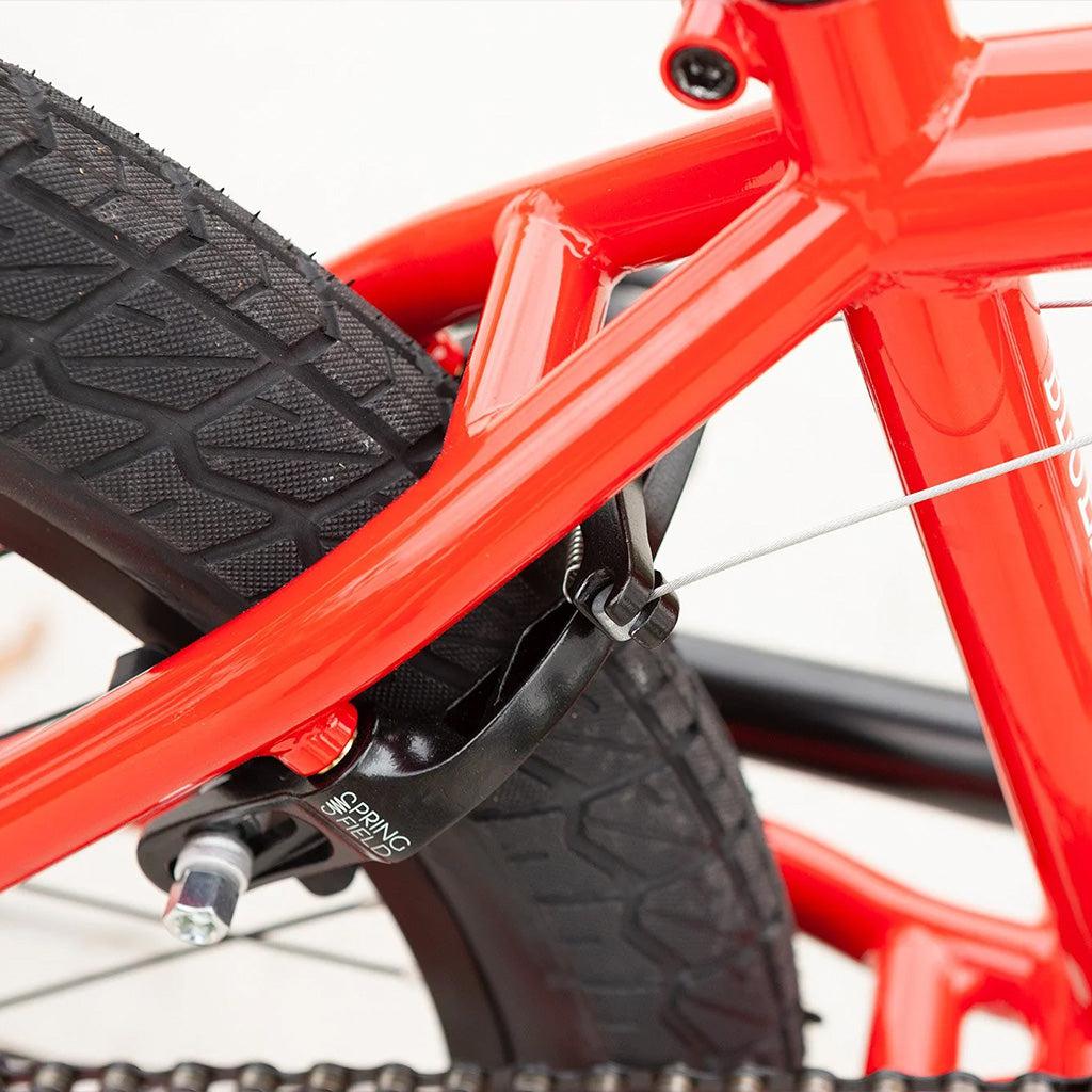 A close up of a red Sunday Blueprint 20 inch Bike with a black front wheel.