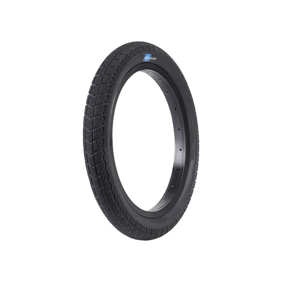 A single black Sunday Current 18 Inch Tyre with a textured tread pattern is displayed on a plain white background. This grippy tire also features a small blue and white label, making it perfect for beginner riders seeking quality and reliability.