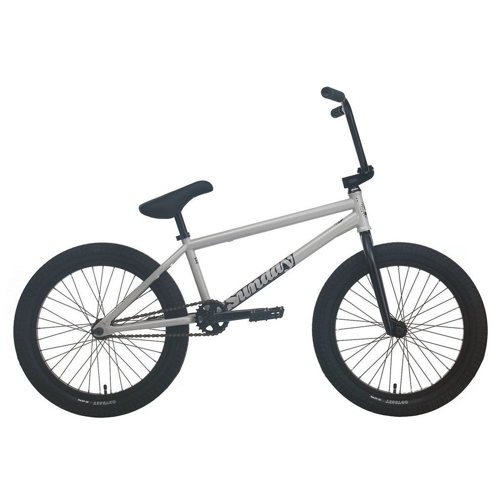 The Sunday EX Erik Elstran 20 Inch Bike features a silver frame, black handlebars, seat, pedals, and tires, a 100% chromoly frame, and Odyssey Springfield Brakes. Shown from the side on a white background.