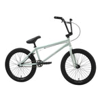 The Sunday Scout 20 Inch Bike features a matte light green finish with black Odyssey handlebars, seat, pedals, and tires. Shown side-on against a white background, its durable chromoly construction ensures lasting performance.