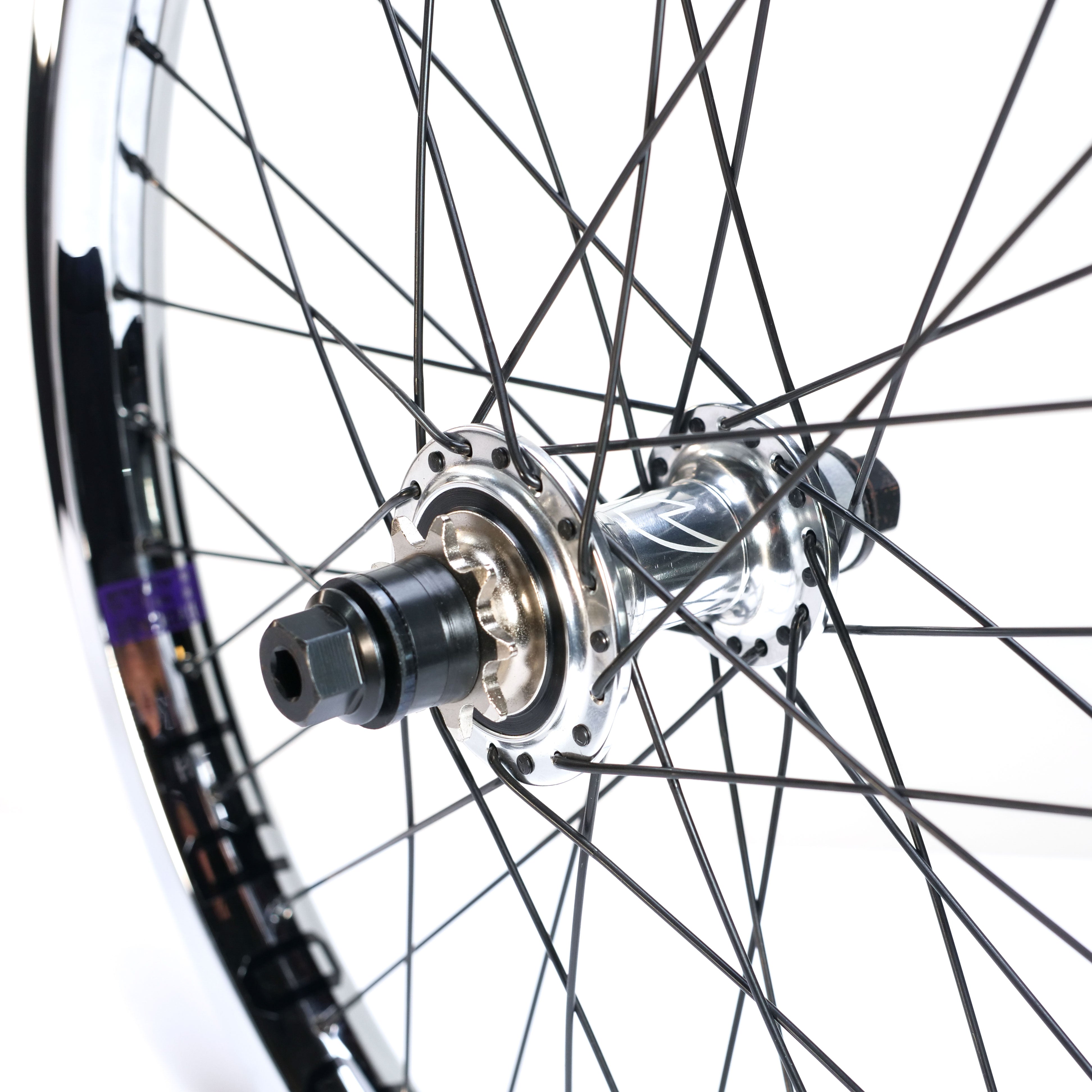 Close-up of the Tall Order X Birdcage Custom Wheelset's bicycle wheel, highlighting metal spokes, a polished hub, and axle components—perfect for BMX builds—set against a white background.