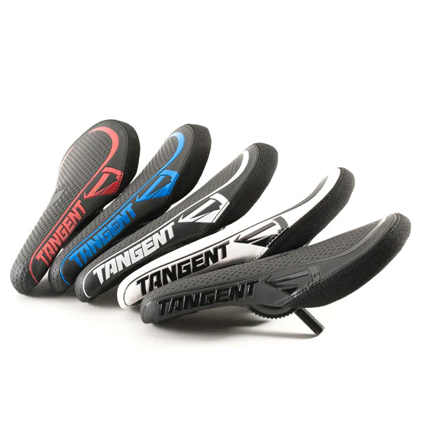 A row of five Tangent Remix Mini Seat seats, designed for junior race bikes, features vibrant colors: red, blue, white, black, and a striking white/black combo.