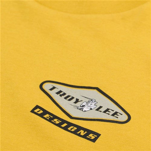 Close-up of the TLD 25.1 Carb SS T-Shirt in vibrant yellow, featuring the "Troy Lee Designs" logo and a bold helmeted figure illustration—ideal for fans eager to showcase their passion for TLD.