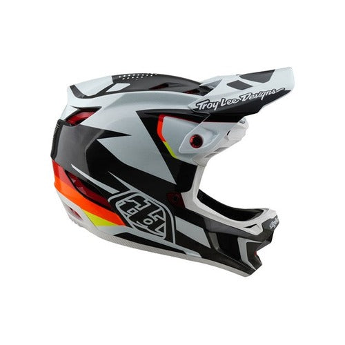 The TLD 25.1 D4 Carbon Helmet (MIPS) in Optic Black features a bold geometric black, white, and red design with "Troy Lee Designs" text and a red circular side vent—ideal for road warriors and downhill BMX enthusiasts.
