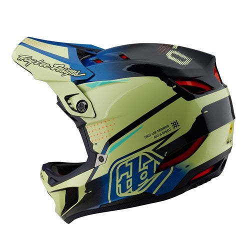 A green and black full-face BMX racing helmet with blue accents, red vents, and eye-catching graphics featuring "Troy Lee Designs" and "Husqvarna" logos. The TLD 25.1 D4 Composite Helmet (MIPS) / Glo Yellow offers enhanced safety with MIPS technology.