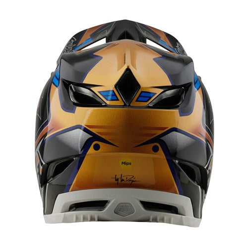 A vibrant TLD 25.1 D4 Composite Helmet (MIPS) in Royalty Black/Gold displays geometric patterns and a sleek ventilation design, offering superior safety with MIPS protection.