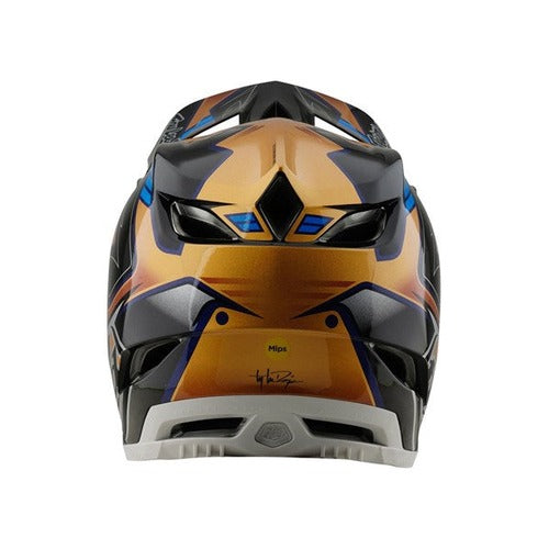 A vibrant TLD 25.1 D4 Composite Helmet (MIPS) in Royalty Black/Gold displays geometric patterns and a sleek ventilation design, offering superior safety with MIPS protection.