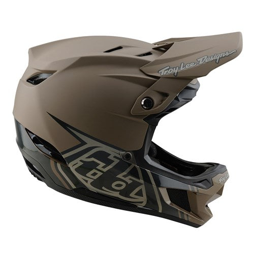 The TLD 25.1 D4 Composite Helmet (MIPS) / Stealth Caper is a matte brown downhill helmet with an angular design, featuring the Troy Lee Designs logo, full-face coverage, a visor, ventilation openings, and MIPS protection for enhanced safety.