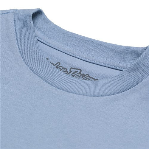 A close-up of the TLD 25.1 Peace Out SS T-Shirt (Youth) in light blue highlights its neckline with visible stitching, showcasing the quality of this legendary brand, and features a partially obscured logo on the inner label.