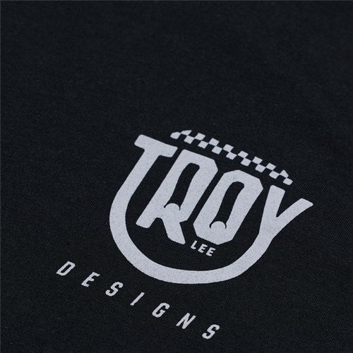 The TLD 25.1 Smiley SS T-Shirt, featuring black fabric with a white "Troy Lee Designs" logo and a curved checkered line above it, is perfect for brightening your day with its stylish design.