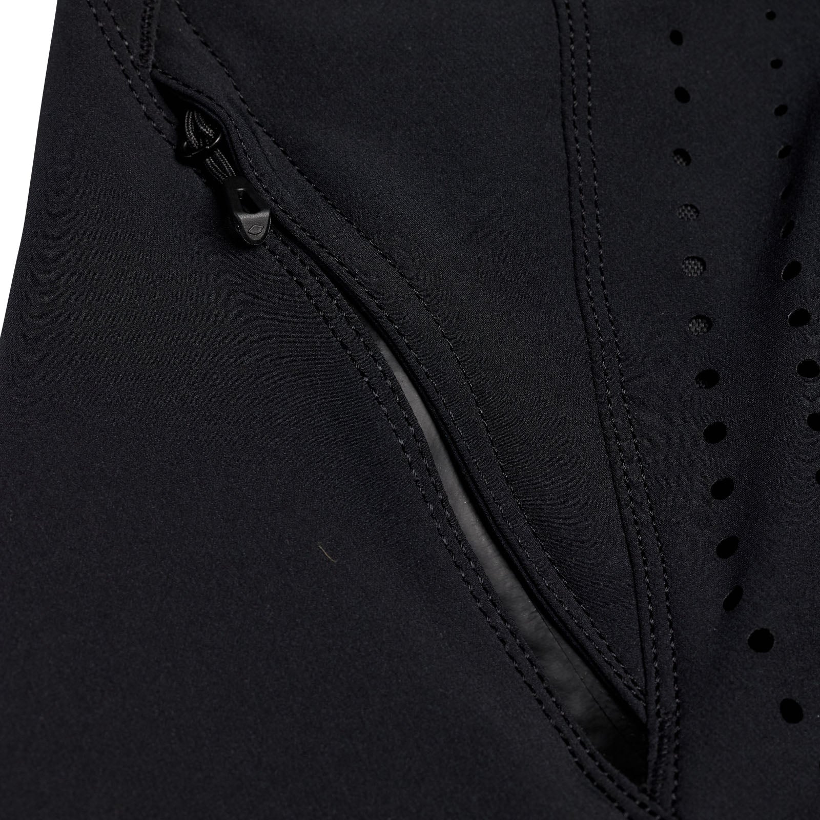 Close-up of the TLD 25.1 Sprint Pant / Mono Black fabric, showcasing its zipper and small holes, reminiscent of meticulous design details.