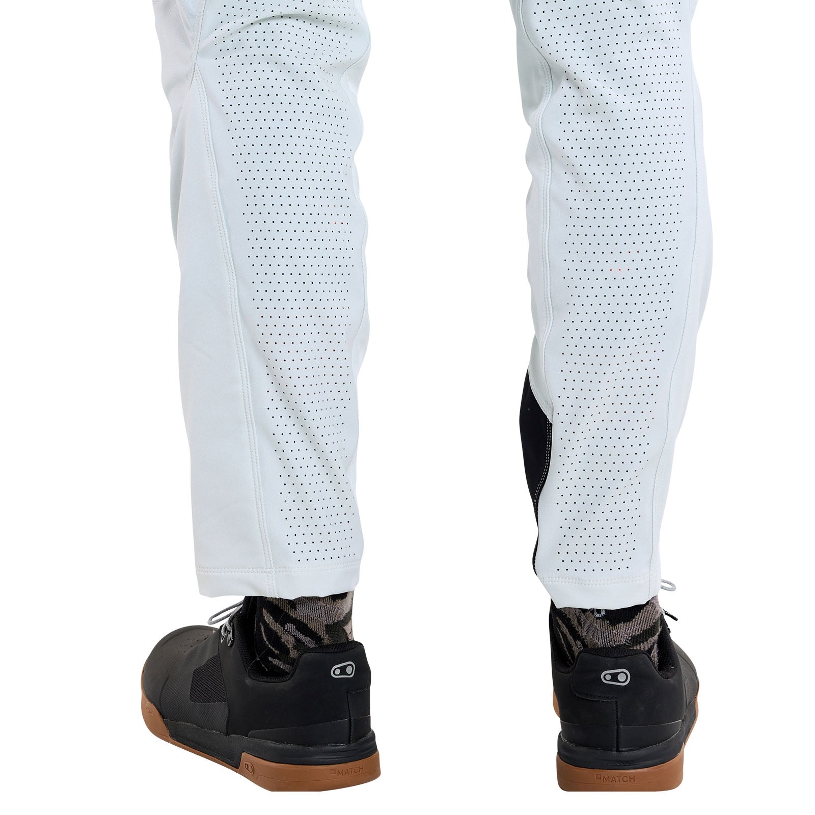 Back view of a person wearing TLD 25.1 Sprint Pant / Mono Chalk, black sneakers, and patterned socks—ideal race-ready attire for any fast-paced adventure.