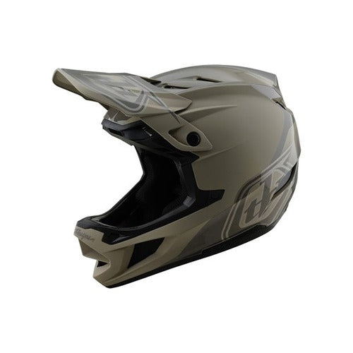 The TLD D4 Polyacrylite Helmet (MIPS) / Shadow Timber is a tan and black full-face motocross helmet with a visor, designed for off-road use. It boasts a durable Polyacrylite shell, vibrant side graphics, and Mips brain protection for superior safety.