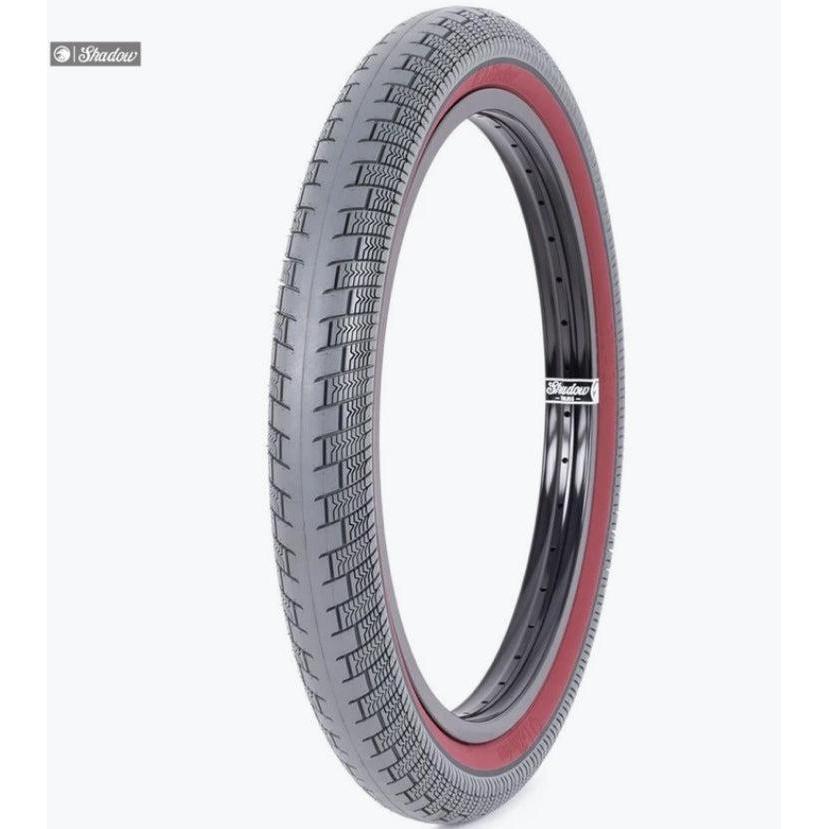 The Shadow Creeper 20 Inch Tyre is a high psi street and park tire featuring a black tread, red sidewall, and black rim, displayed upright against a white background.
