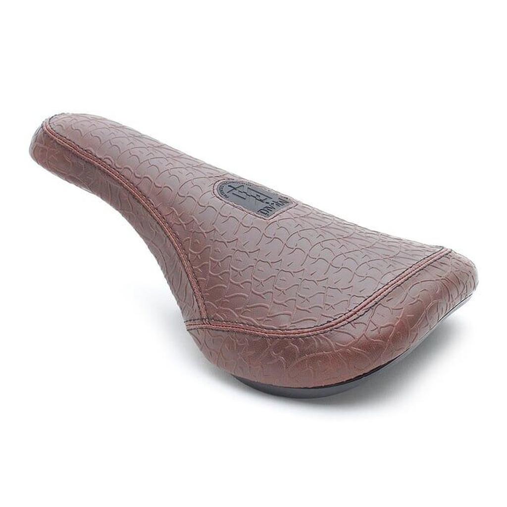 Add style and comfort to your bike with the Stranger Zefaria Pivotal Seat, featuring a brown leather-patterned design, textured surface, and a black logo badge on top.