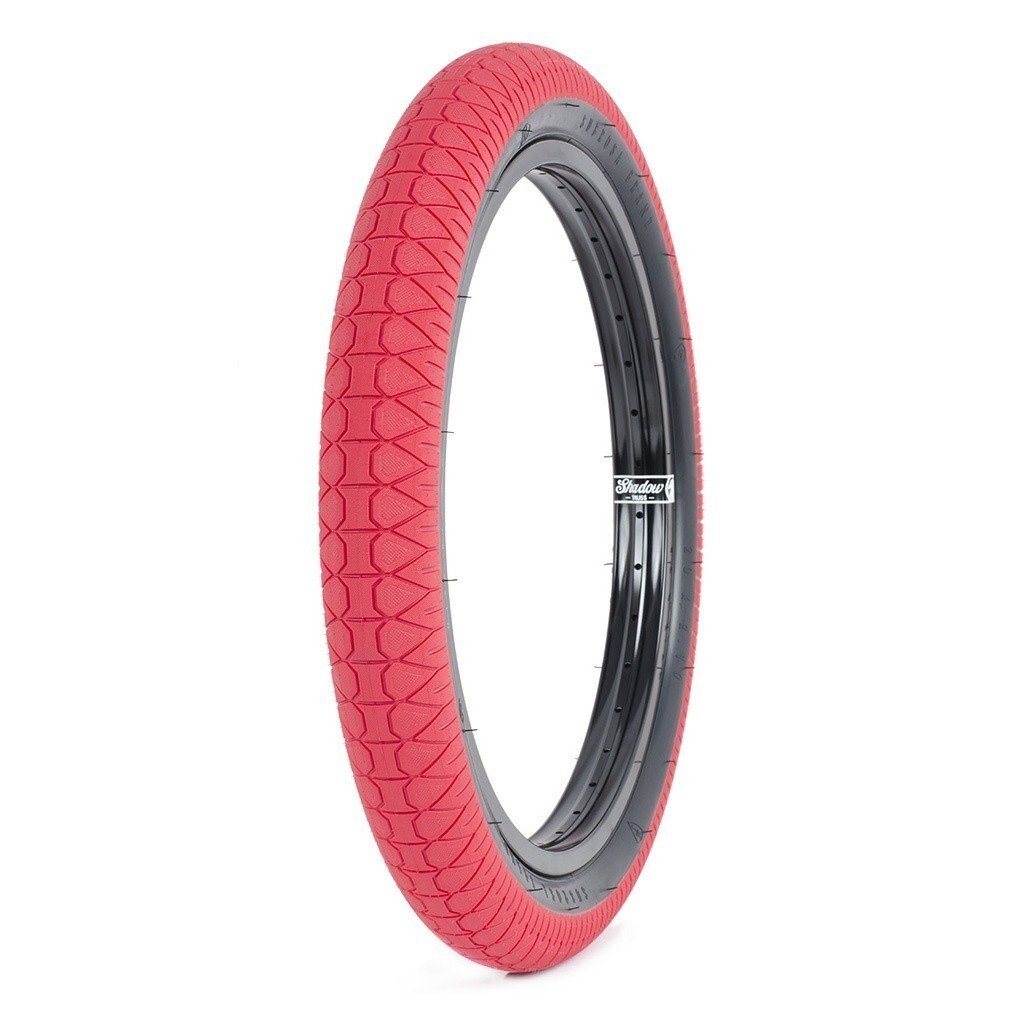A single Subrosa Designer Tyre, featuring a red tread and black inner rim, is displayed upright against a white background.