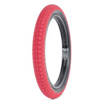 A single Subrosa Designer Tyre, featuring a red tread and black inner rim, is displayed upright against a white background.
