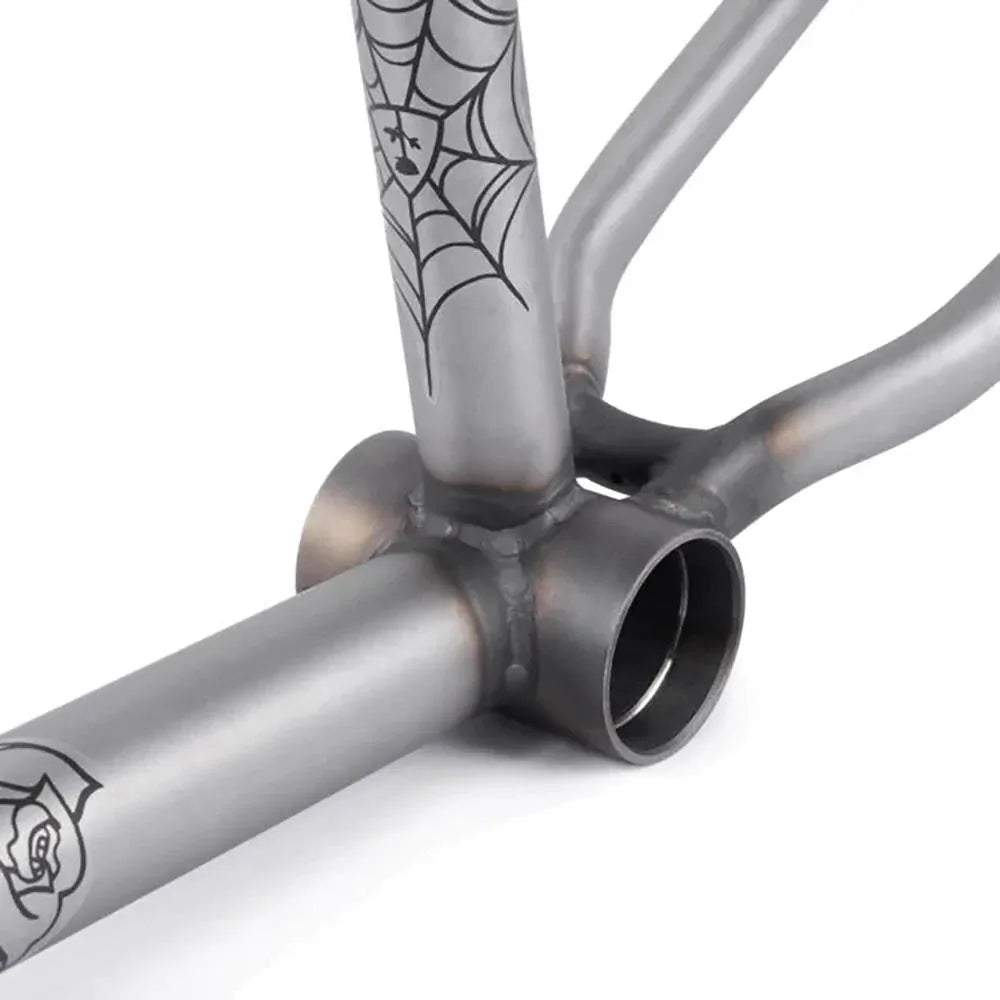 Close-up of the Subrosa Rose Frame, a metallic BMX frame made from 4130 chromoly with welded joints and black line art designs of a spider web and rose.