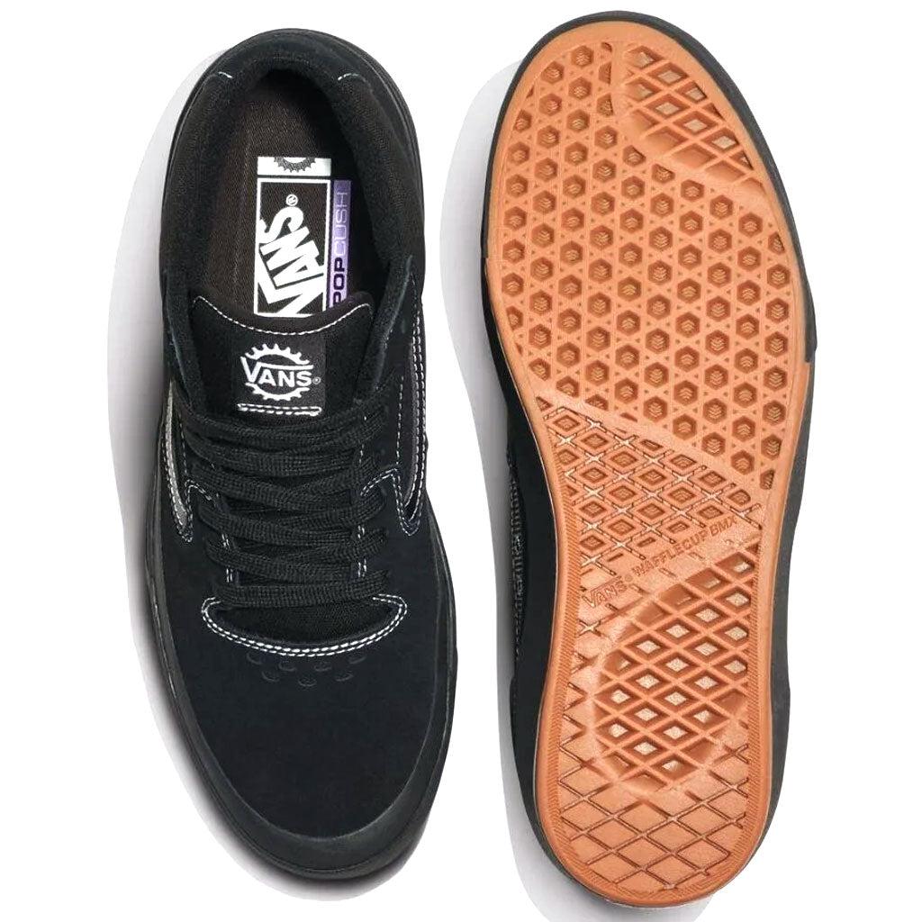 Top and bottom view of the Vans BMX Style 114 Black/White skate shoes with a rubber waffle sole. The top view showcases white stitching and laces, while the bottom view emphasizes the grip pattern, reflecting their durability and cushioning, making them ideal for BMX enthusiasts.