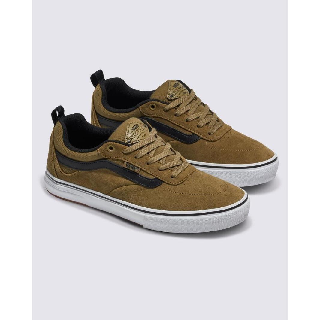 Introducing the Vans Pro Skate Kyle Walker in Gothic Olive: a pair of brown suede sneakers with white soles and black accents, featuring the iconic Vans logo on both the tongue and side. These shoes showcase Kyle Walker's signature design and are built with WAFFLECUP™ technology for exceptional support, along with DURACAP™ reinforcement for lasting durability.