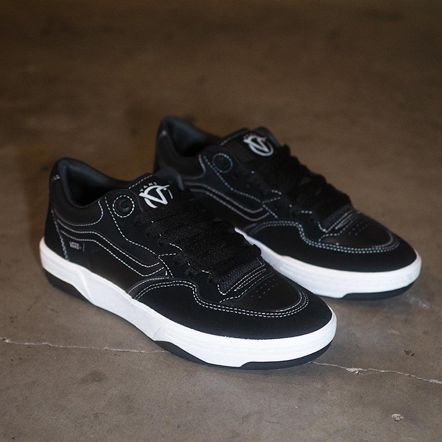 A pair of Vans Rowan 2 Shoes - Black/White, designed for skateboarding, on a concrete floor.