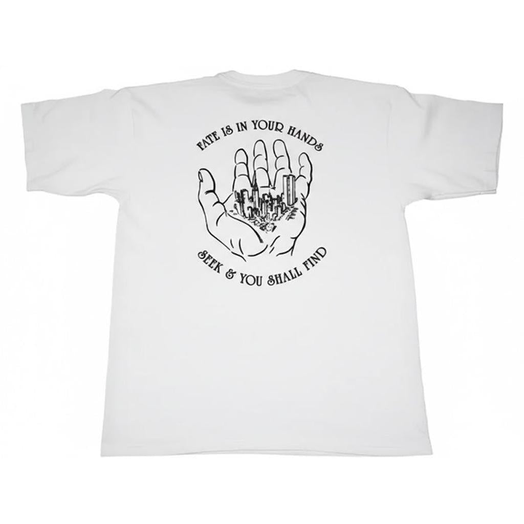 The AM:PM Fate T-Shirt (Street Advisors) is a white Bayside USA 100% cotton tee with a black hand holding a cityscape line drawing and the words “Fate is in your hands. Seek & you shall find.”.