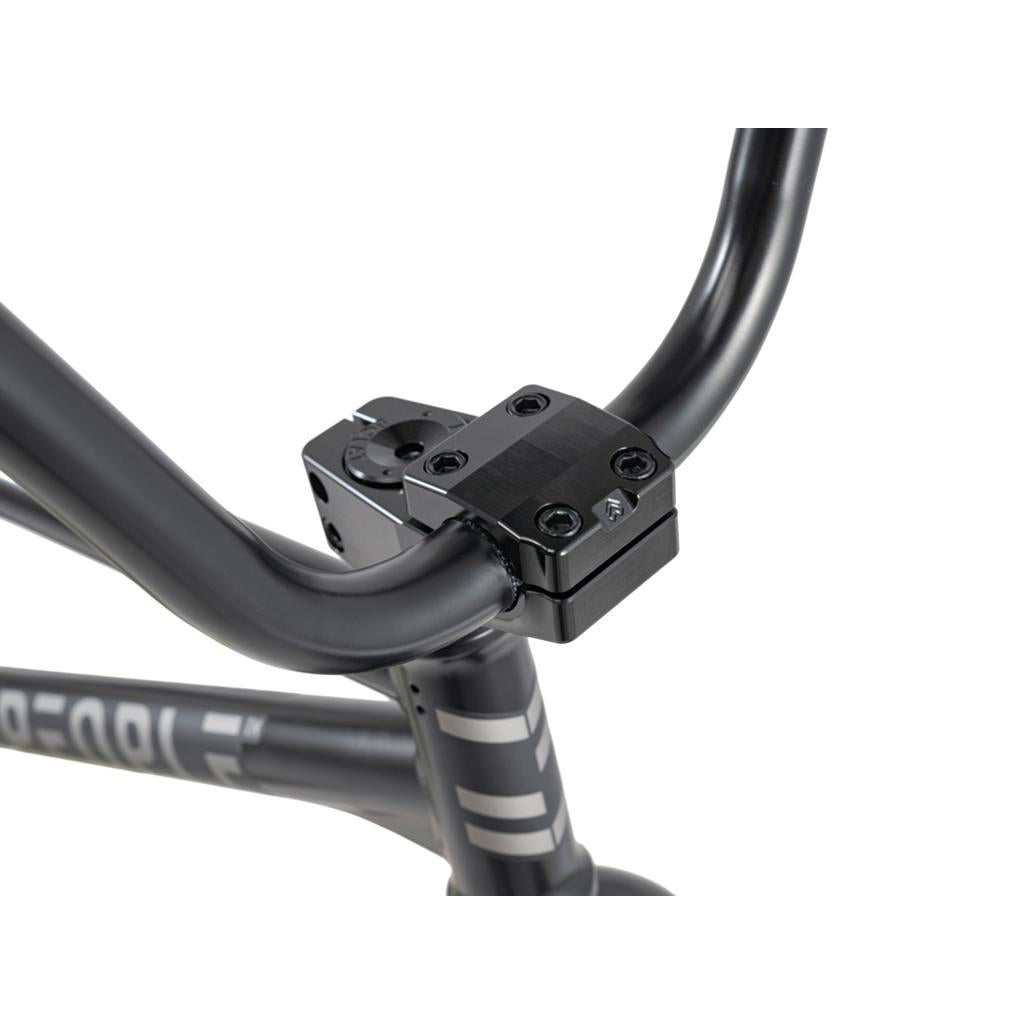 Close-up of Wethepeople 20 inch Envy Carbonic LTD Bike handlebars and stem, showcasing the handlebar clamp, white frame graphics, and sleek carbon fibre rims on this premium ride.